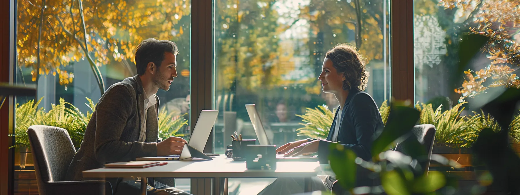two business professionals comparing customer support resources on their laptops.