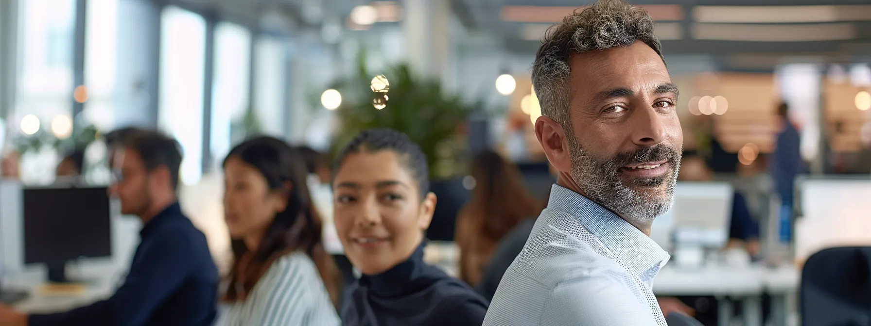 professional looking individuals smiling and working together in a modern office environment.